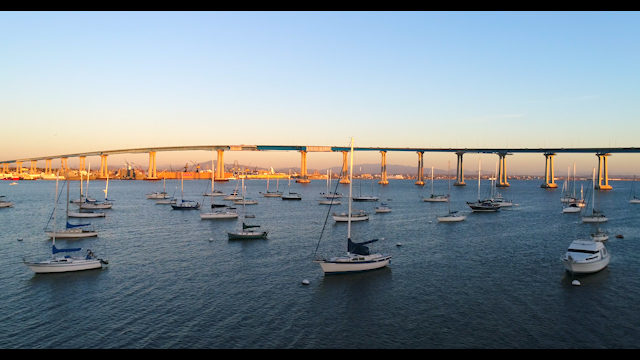 Low aerial view of the harbor, the bridge and boats in Coronado, with boats out.