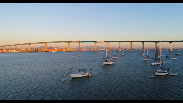 Low aerial view of the harbor, the bridge and boats in Coronado, with boats out.