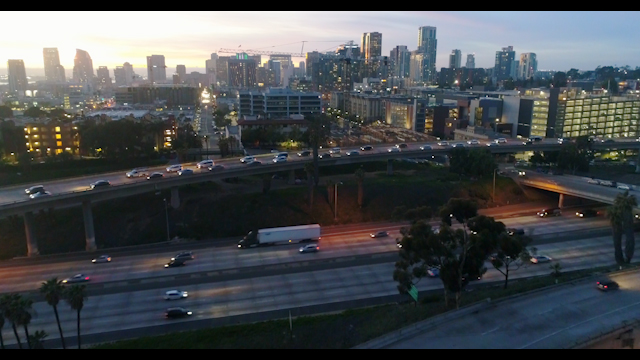 Low aerial view of the downtown streets, the bridge and the skyline in Downtown San Diego.