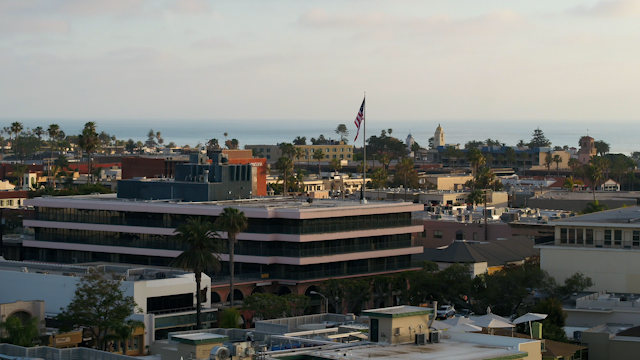 Low aerial view of the downtown streets, palm trees and the ocean at La Jolla Cove.