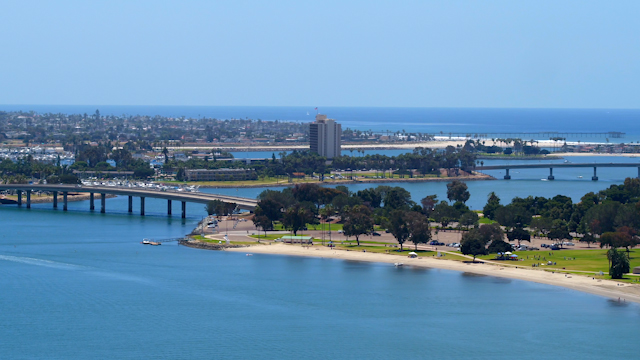 Aerial view of a park, the bridge and boats in Mission Bay, with people walking.