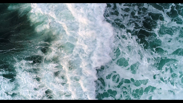 Aerial view of the cliffs, the surf and the ocean at Sunset Cliffs.