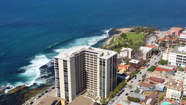 Aerial view of a residential street, the surf and the ocean at La Jolla Cove.