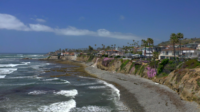 Elevated view of the cliffs, the surf and palm trees at Bird Rock.