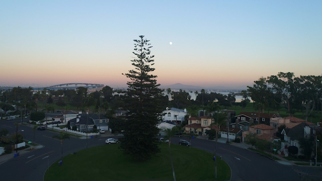 Low aerial view of a residential street, the bay and homes in Coronado.