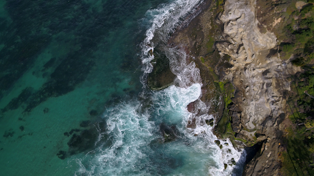 Aerial view of the cliffs, the surf and the ocean at Windansea.