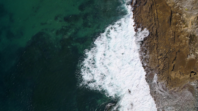Aerial view of the cliffs, the surf and the ocean at Windansea.
