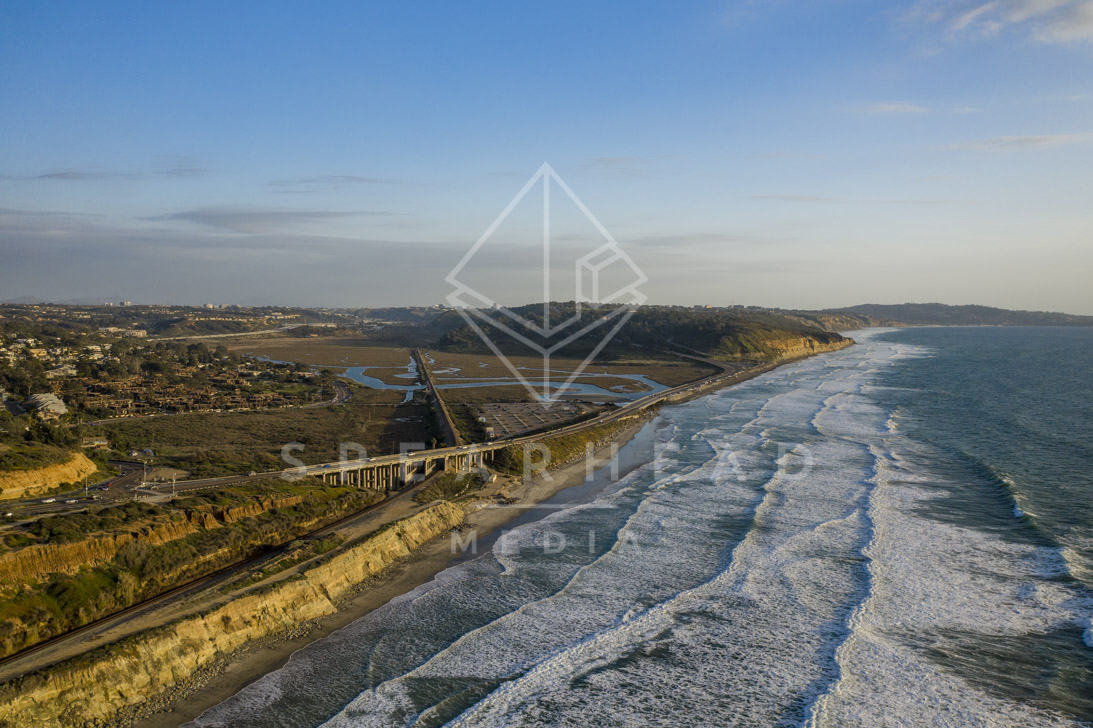 Aerial view of the cliffs, the surf and the bridge in Del Mar.