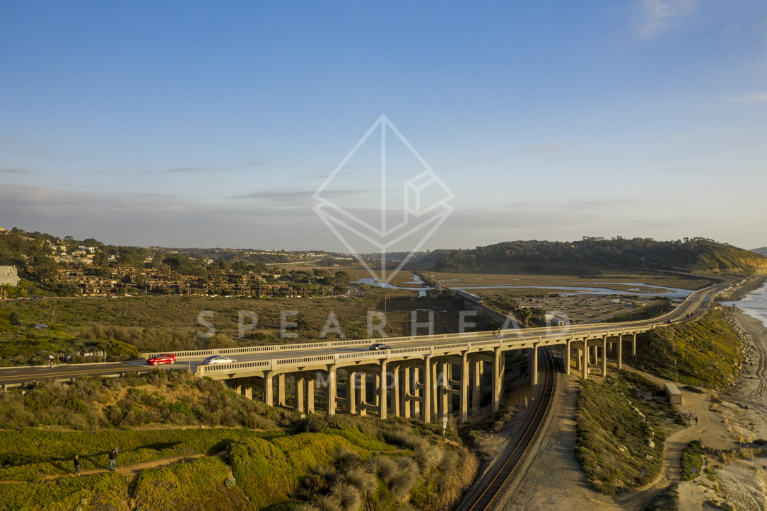 Aerial view of the country inland, the bridge and homes in Del Mar, with people walking.