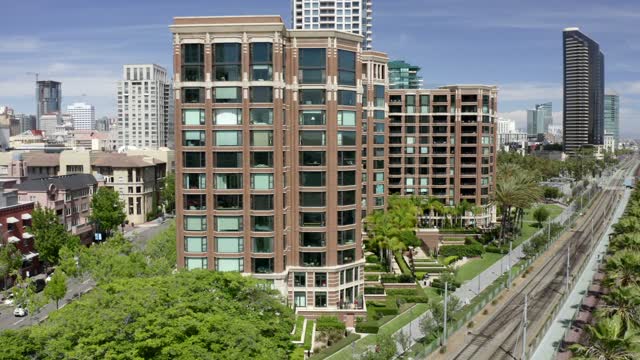 Low aerial view of the downtown streets, the skyline and palm trees at Marina.