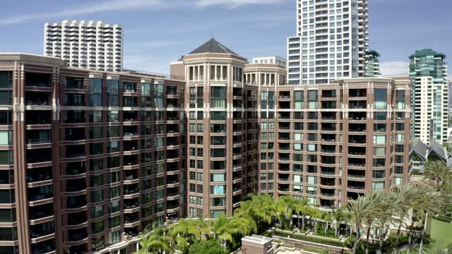 Low aerial view of the downtown streets, the skyline and palm trees at Marina.