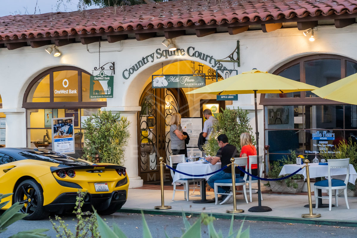 The downtown streets, the buildings and traffic at Covenant, with people eating outside.