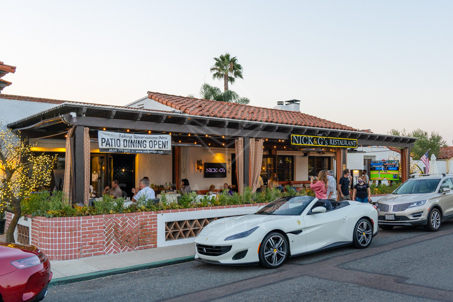 The downtown streets, palm trees and the buildings at Covenant, with people eating outside.