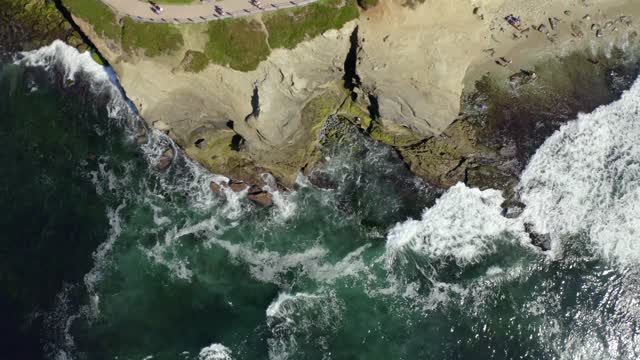 Aerial view of the cliffs, the surf and the ocean at La Jolla Cove.