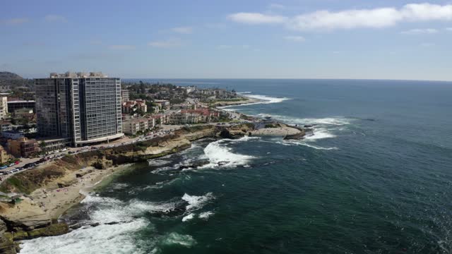 Aerial view of the cliffs, the surf and the ocean at La Jolla Cove.