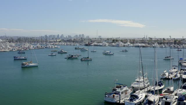 Low aerial view of the harbor, the skyline and boats in Point Loma, with boats out.