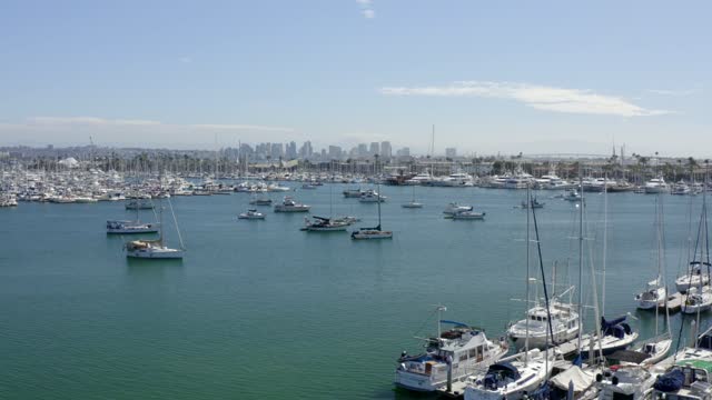 Low aerial view of the harbor, the skyline and boats in Point Loma, with boats out.