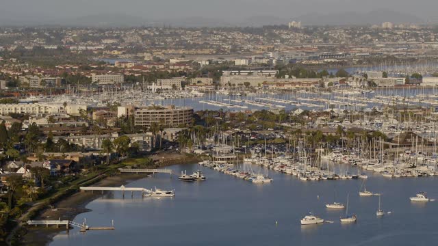 Aerial view of the harbor, boats and palm trees in Point Loma, with boats out.