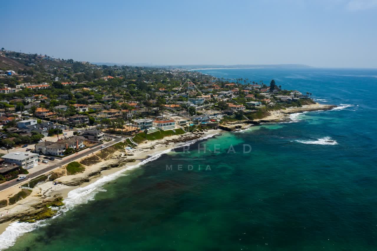 Aerial view of the cliffs, the surf and palm trees at Windansea.