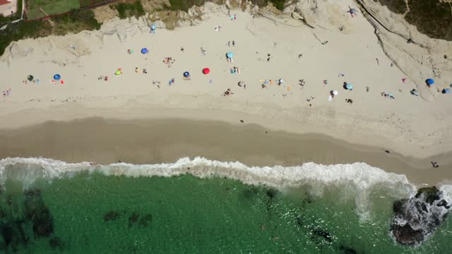 Aerial view of the beach, the surf and the ocean at Windansea, with a crowd gathered.