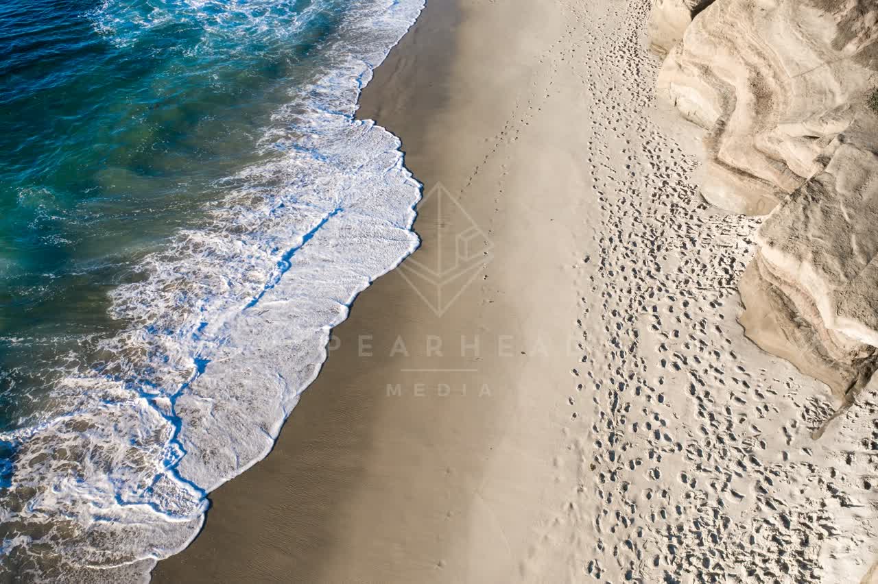 Aerial view of the beach, the surf and the ocean at La Jolla Cove.