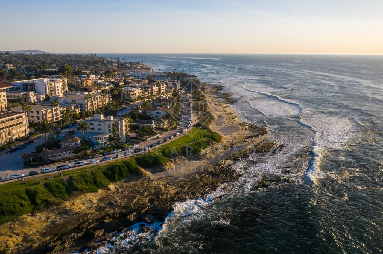 Aerial view of the cliffs, the surf and palm trees at La Jolla Cove.