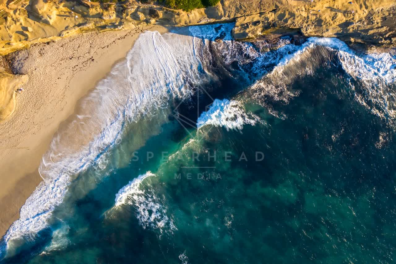 Aerial view of the cliffs, the surf and the ocean at La Jolla Cove.