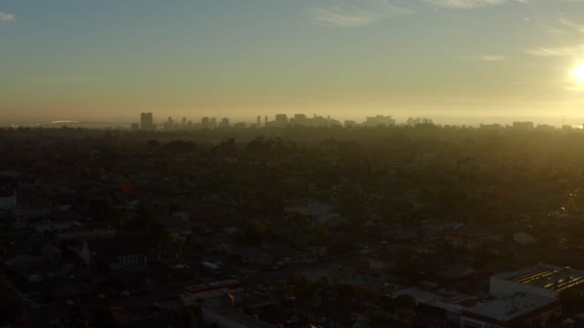 Low aerial view of a residential street, the skyline and homes in North Park.