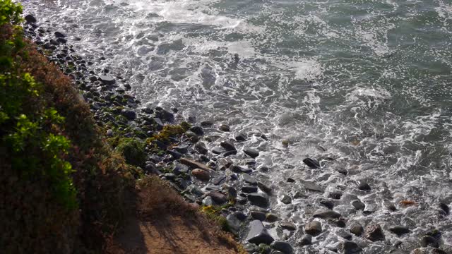 Elevated view of the cliffs, the surf and the ocean at Bird Rock.