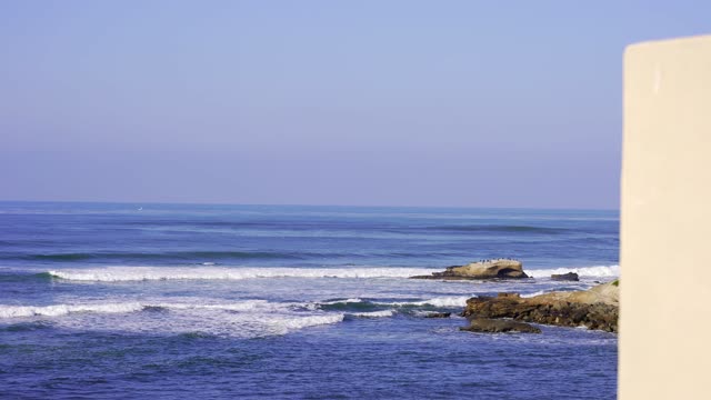 Elevated view of the cliffs, the surf and the ocean at Bird Rock.