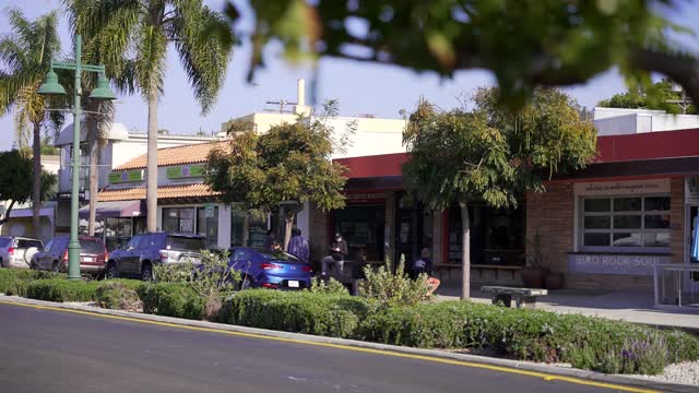 The downtown streets, palm trees and the buildings at Bird Rock, with people walking.