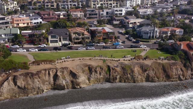Aerial view of a residential street, the ocean and homes at Bird Rock, with people walking.
