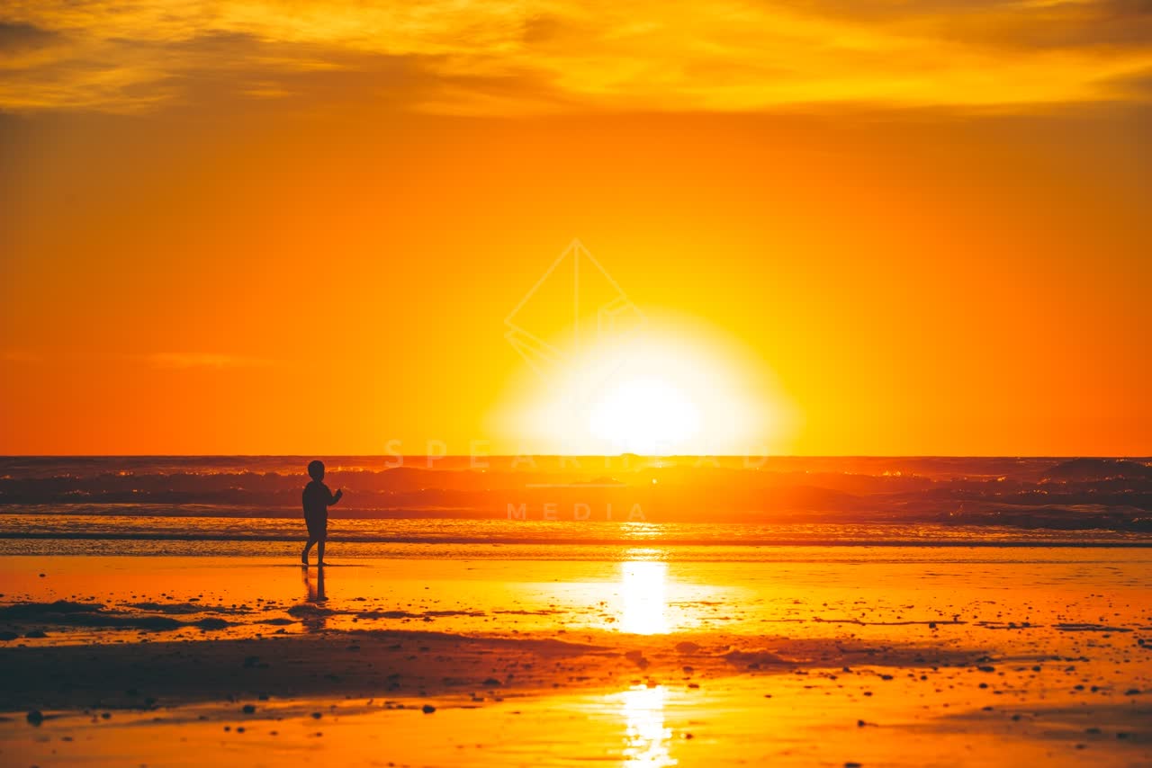 The beach, the surf and the ocean in Del Mar, with people walking.