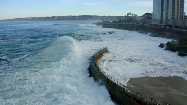 Aerial view of the cliffs, the surf and the ocean at La Jolla Cove.