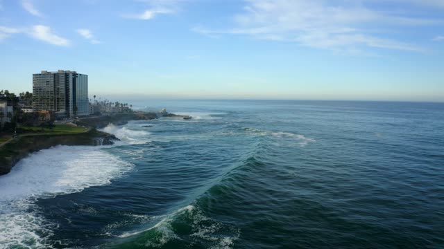 Aerial view of the cliffs, the surf and the ocean at La Jolla Cove.