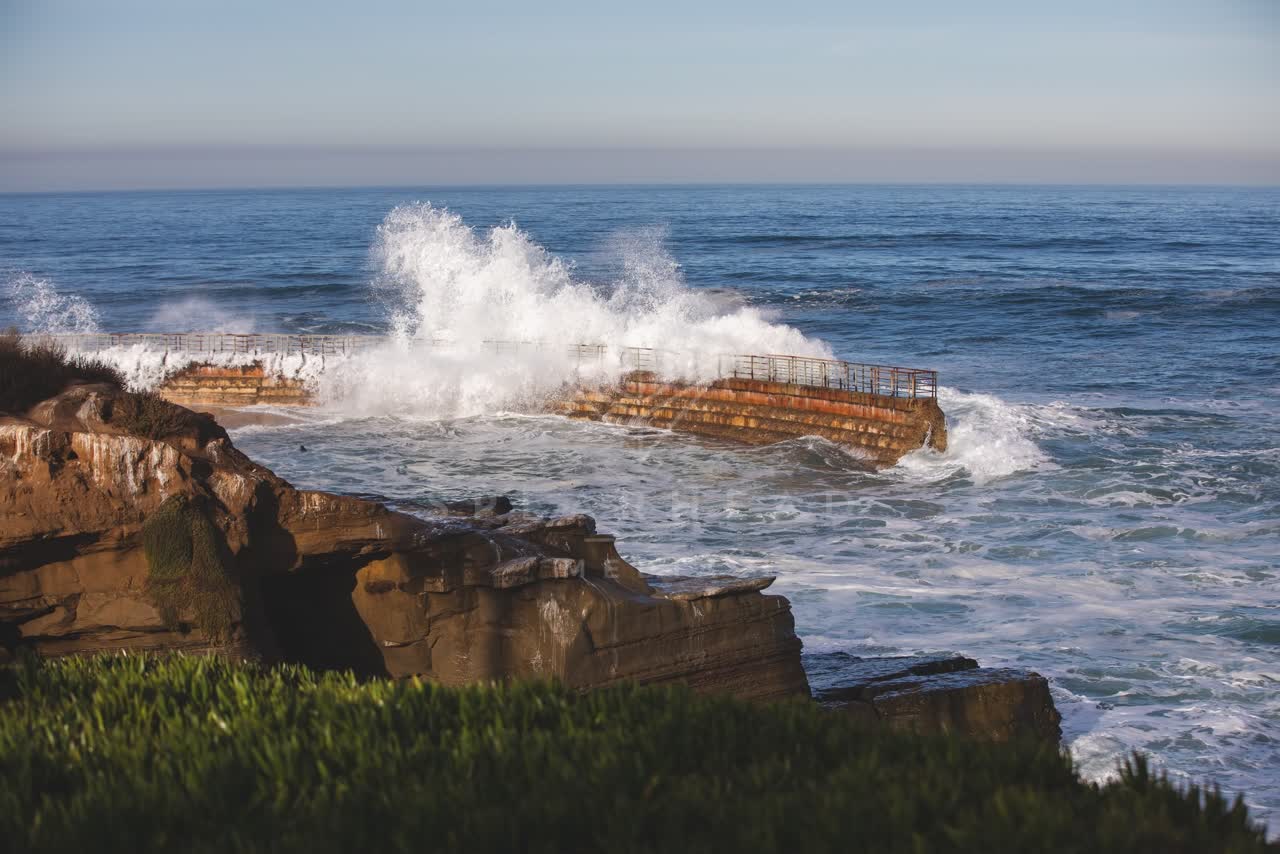 Elevated view of the cliffs, the surf and the ocean at La Jolla Cove.