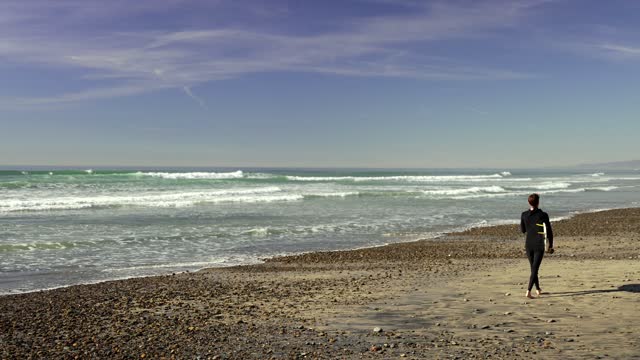 The beach, the surf and the ocean at Leucadia, with people walking.