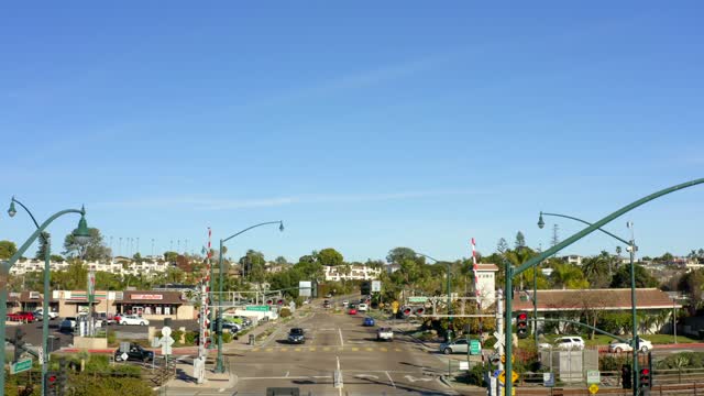 Low aerial view of the downtown streets, palm trees and the buildings at Leucadia.