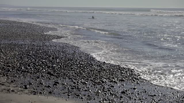 The beach, the surf and the ocean at Leucadia, with swimmers in the water.