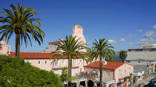 Low aerial view of the downtown streets, palm trees and the ocean at La Jolla Cove.