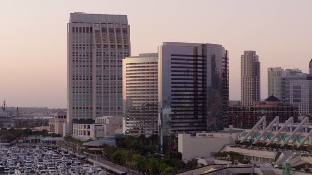 Low aerial view of the downtown streets, the skyline and boats at Marina.