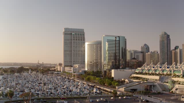 Low aerial view of the downtown streets, the skyline and boats at Marina.