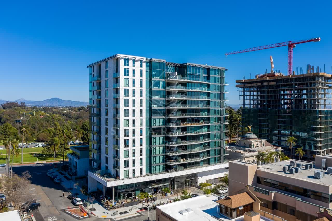 Aerial view of the downtown streets, the skyline and palm trees at Bankers Hill, with a work crew on site.