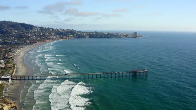 Aerial view of the beach, the surf and the pier at La Jolla Cove.