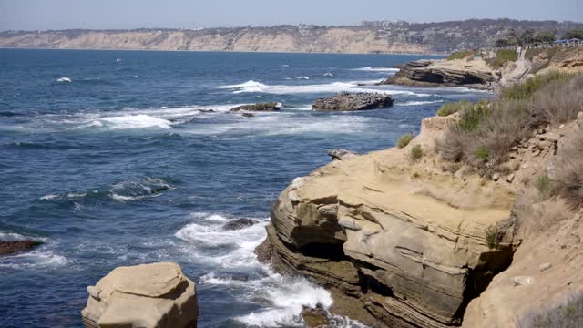 Elevated view of the cliffs, the surf and the ocean at La Jolla Cove.