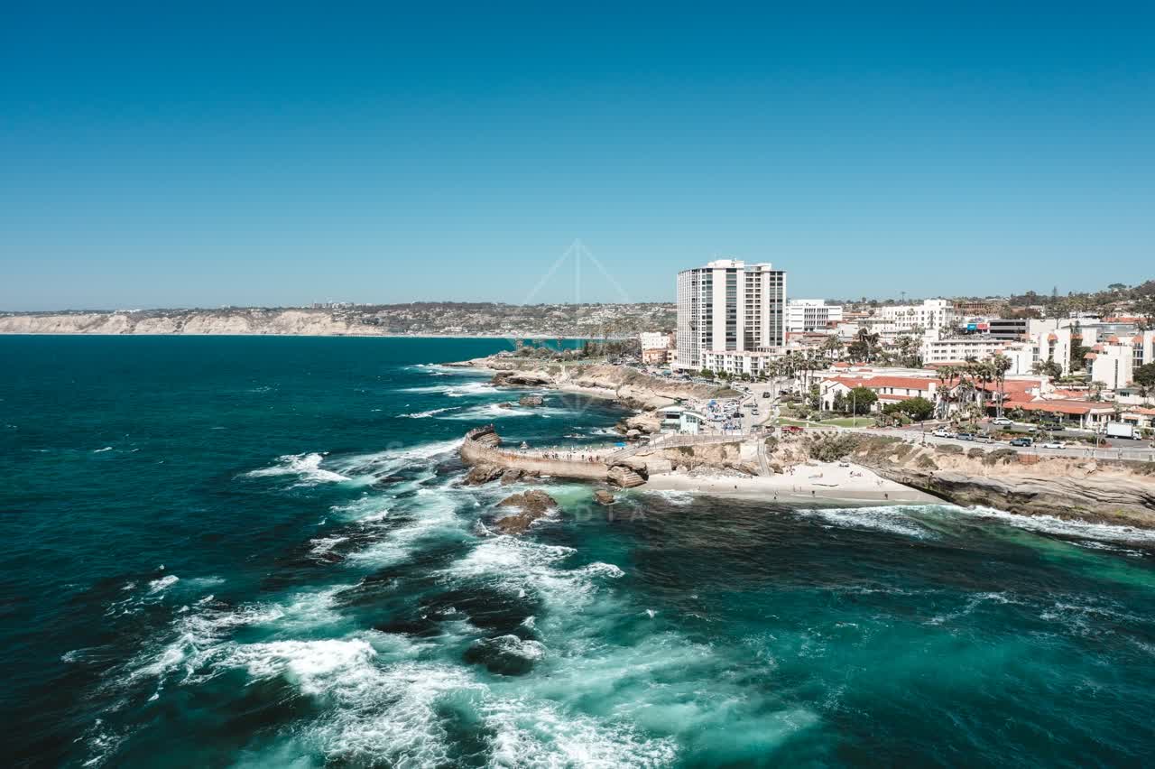 Aerial view of the cliffs, the surf and the ocean at La Jolla Cove.