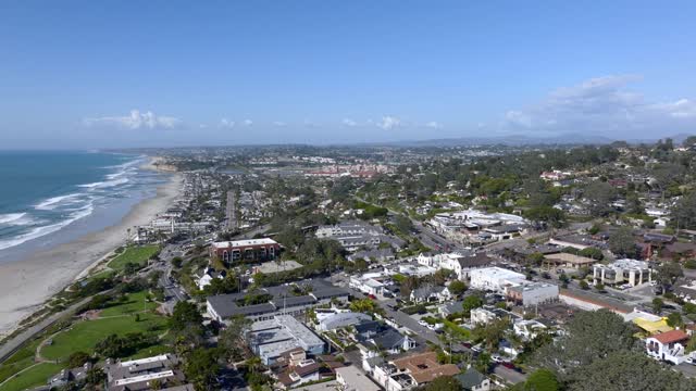 Aerial view of a residential street, the surf and palm trees at Powerhouse Park.