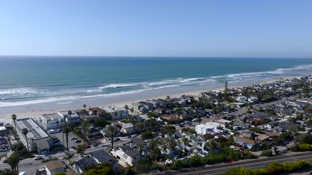 Aerial view of a residential street, the surf and palm trees at Powerhouse Park.