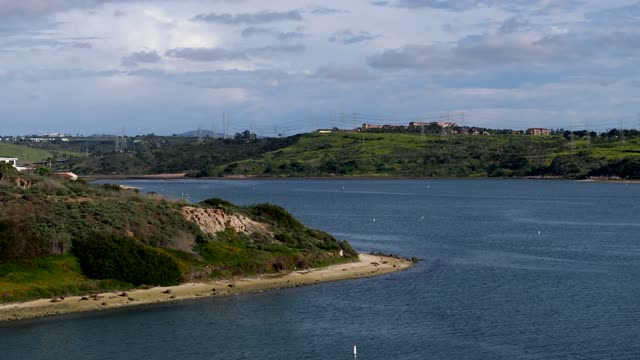 Low aerial view of the country inland, the bay and homes in Carlsbad.