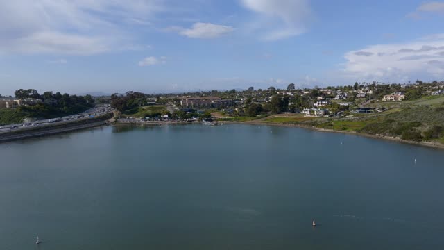 Low aerial view of a residential street, the bay and homes in Carlsbad.